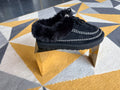 Black faux-fur moccasin slippers.