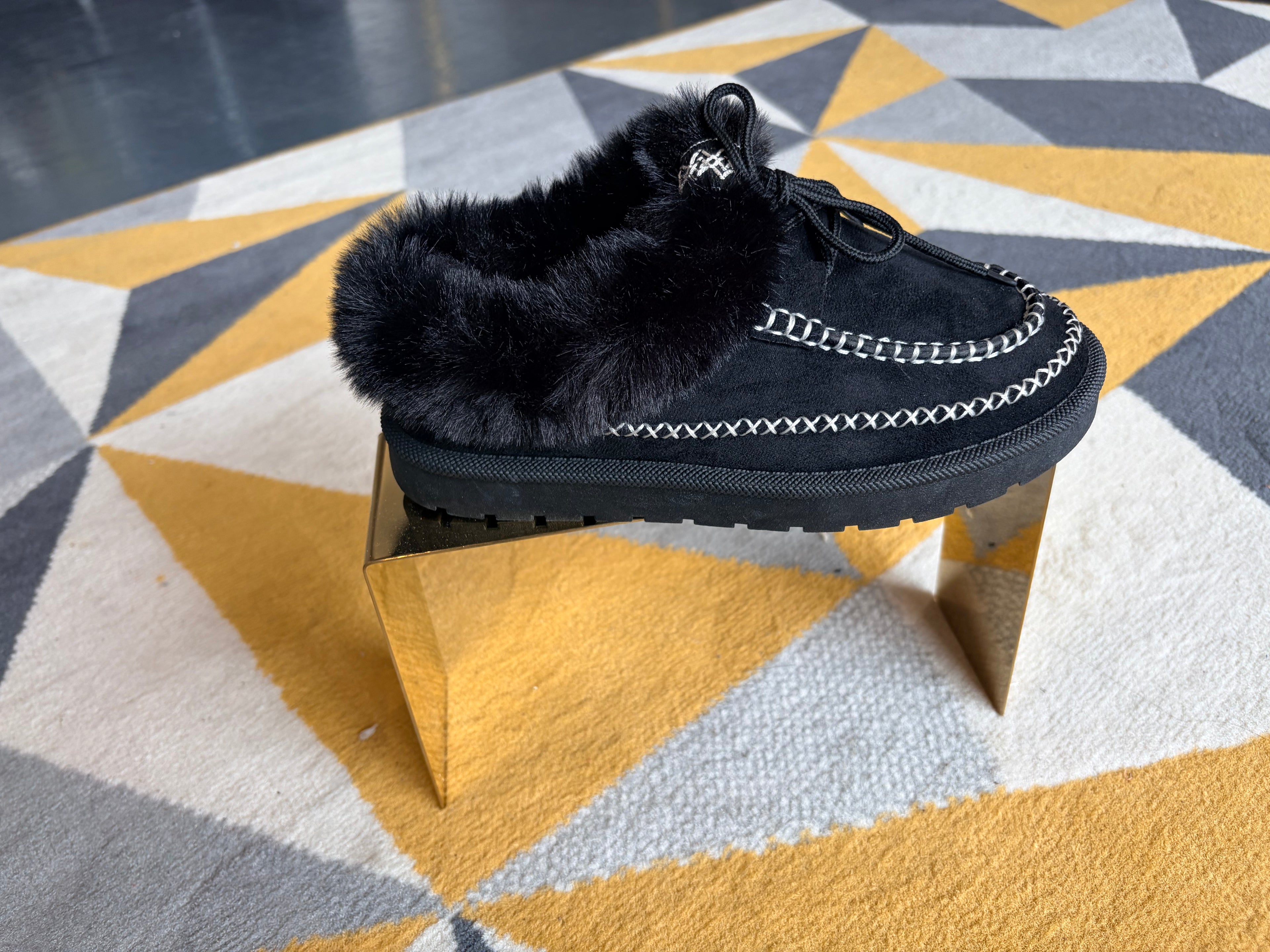 Black faux-fur moccasin slippers.